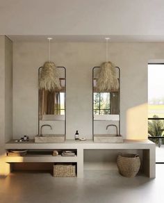 a bathroom with two sinks and mirrors on the wall next to a large window in front of it