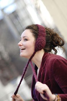 a woman wearing a knitted headband and smiling