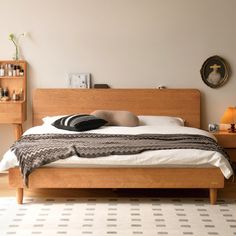 a bed sitting in a bedroom next to a wooden dresser and table with a hat on top of it