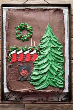 a cake decorated with green icing and christmas decorations on top of a wooden table