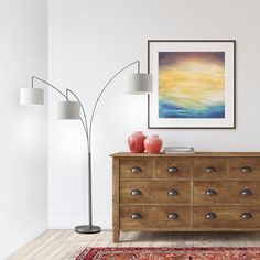 a living room scene with focus on the dresser and floor lamp in the foreground