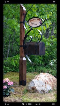 a sign that is on the side of a wooden pole in front of some flowers