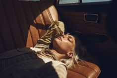 a woman laying in the back seat of a car