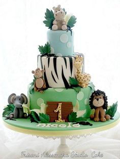 a three tiered cake with animals and giraffes on it