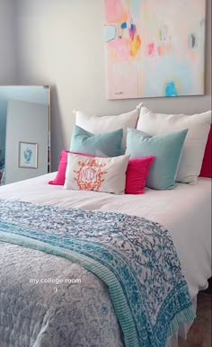 a large bed with colorful pillows and blankets on it's headboard in a bedroom