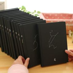 someone is holding an open book in front of them with drawings on the pages,