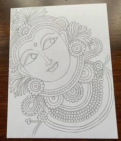 a drawing of a woman's face on top of a piece of white paper