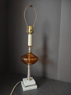 an antique table lamp with a glass shade on it's base and a cord attached to the top