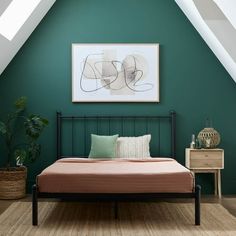 a bed in a room with green walls and wooden flooring next to a painting on the wall