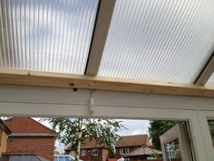 an open patio door leading to a house with red brick buildings in the back ground