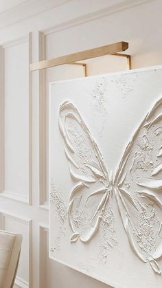 a white wall with a butterfly on it