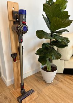 a potted plant sitting on top of a wooden floor next to a wall mounted device