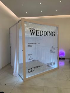 an advertisement for a wedding on display in a room with white walls and tile flooring