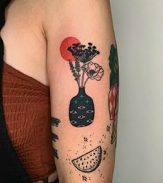 a woman with a tattoo on her arm has flowers in a vase and watermelon