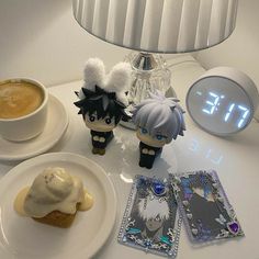 an alarm clock sitting on top of a table next to two cupcakes