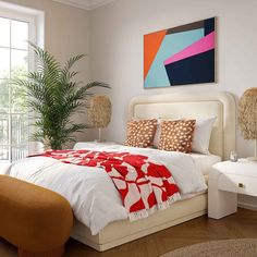 a bedroom with white walls and wooden flooring has a large painting on the wall above the bed