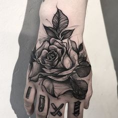 a black and white rose tattoo on the left hand