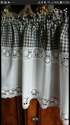 an image of curtains with white lace and black checkerboard on the bottom curtain