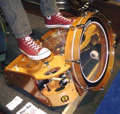 a person standing on top of a wooden drum kit with wheels and drumsticks