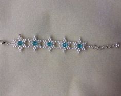 the bracelet is adorned with pearls and blue stones