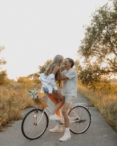 a man riding on the back of a bike next to a woman in white dress