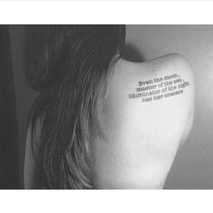 the back of a woman's neck with a quote on it