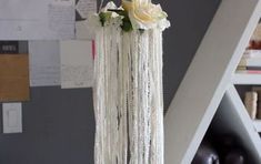 there is a white flower hanging from the ceiling next to some bookshelf shelves