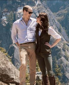 a man and woman standing on top of a mountain