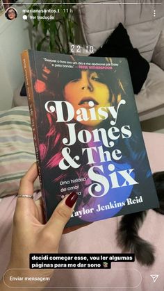 the book daisy jones and the six is being held up by someone's hand