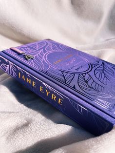 a purple book sitting on top of a white sheet