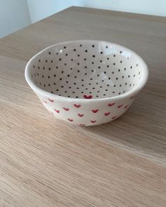 a polka dot bowl sitting on top of a wooden table