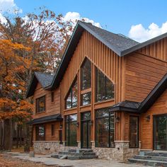 a large wooden house with many windows and steps leading up to the front door area