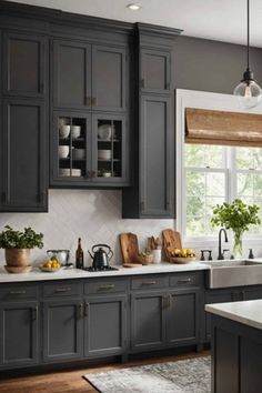 a kitchen filled with lots of gray cabinets and white counter top space next to a window