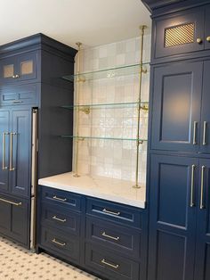 a kitchen with blue cabinets and gold pulls on the doors is pictured in this image