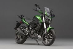 a green and black motorcycle is parked on a gray background