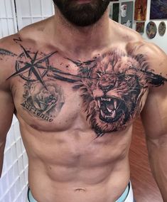 a shirtless man with tattoos on his chest has a lion and cross tattoo on his chest