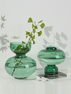 two green vases sitting next to each other on a table