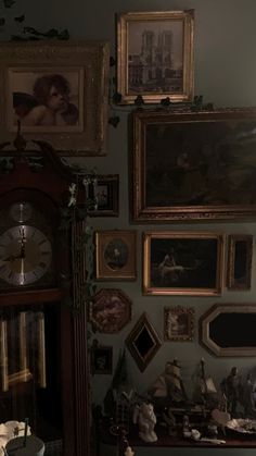 there are many framed pictures on the wall in this room, including an old grandfather clock