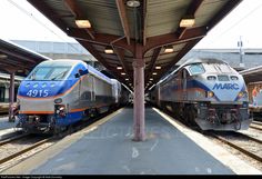 two trains parked next to each other at a train station