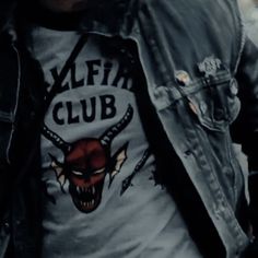 a man wearing a black leather jacket with a red bull t - shirt on it