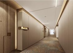 an empty hallway leading to two elevators in a modern office building with wood paneling