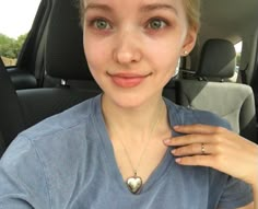 a woman sitting in the back seat of a car with her hand on her shoulder