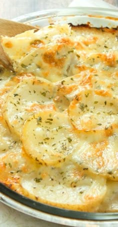 baked potato casserole in a glass dish with a wooden spoon on the side