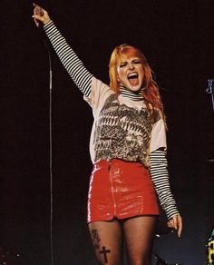 a woman with red hair is singing on stage