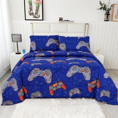 a blue comforter set with video game controllers on it and white furnishing