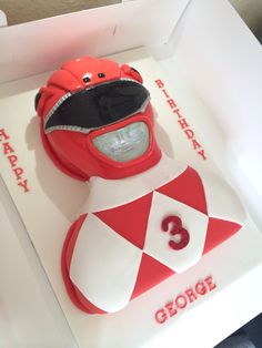 a birthday cake in the shape of a red and white motorcycle helmet with number 3 on it