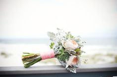 a bouquet of flowers sitting on top of a rail