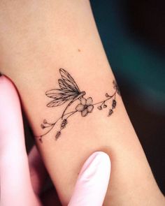 a woman's arm with a small flower tattoo on the left side of her body