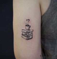 a black and white tattoo of a stack of books with a cup of coffee on top