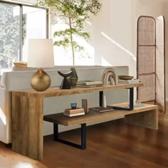 a living room with a couch, coffee table and vases on the end tables